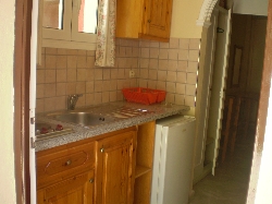 kitchen in a studio with two beds.