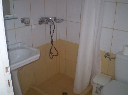 bathroom in a studio with two beds.