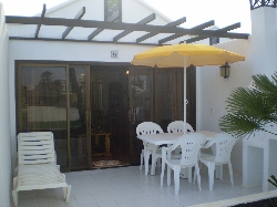 The patio with furniture, parasol + BBQ