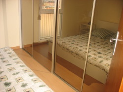 Bedroom with wall to wall mirror closetd